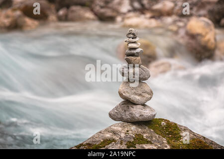 stone tower in front of rapid river Stock Photo