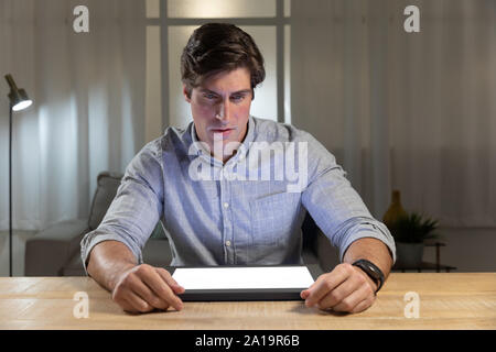 Young man using tablet computer on a table Stock Photo