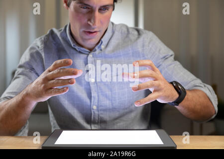 Young man using tablet computer on a table Stock Photo