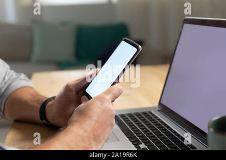 Young man using laptop computer and smartphone Stock Photo