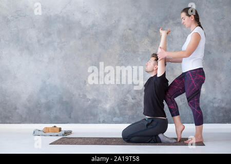 Yoga instructor helping her student to stretch muscles. Wellbeing, wellness concept Stock Photo