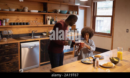Couple eating and having coffee in their kitchen Stock Photo