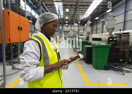 Female factory worker in a large factory warehouse Stock Photo