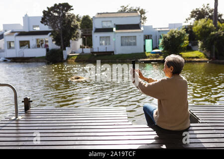 Senior woman using smartphone outdoors Stock Photo