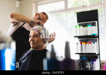 Male hairdresser and female client in hair salon Stock Photo