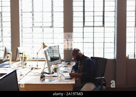 Young creative professional man working in a sunlit office Stock Photo
