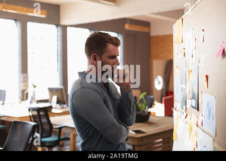 Young creative professional man working in a sunlit office Stock Photo