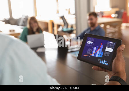 Young creative professional man using tablet in a sunlit office Stock Photo