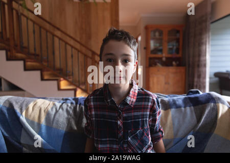 Boy sitting on a couch at home Stock Photo