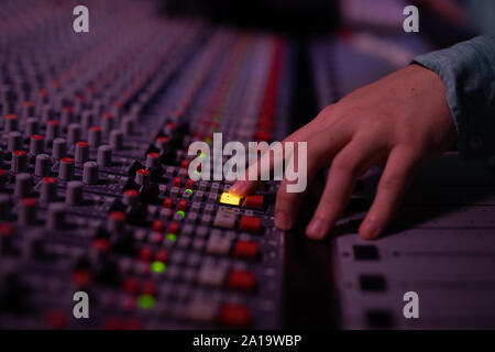 Male music producer working at the mixing desk in a sound studio Stock Photo