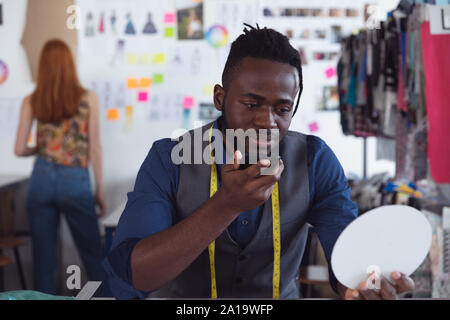 Young male student using smartphone at a fashion college Stock Photo