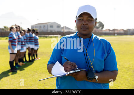 Female rugby coach and team on a rugby pitch Stock Photo