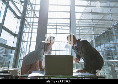 Male and female architects discussing over laptop in office Stock Photo