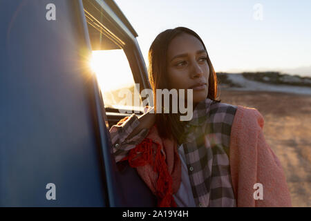 Young woman leaning on a pick-up truck during a stop off on a road trip Stock Photo