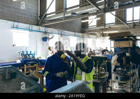 Two men working together in a sports equipment factory Stock Photo