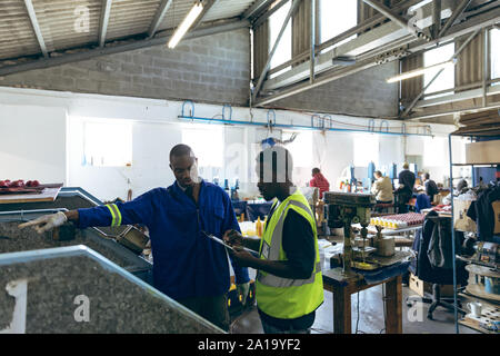 Two men working together in a sports equipment factory Stock Photo