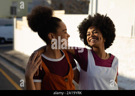 Young women embracing and walking Stock Photo