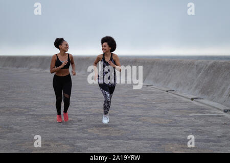 Two young women jogging together Stock Photo