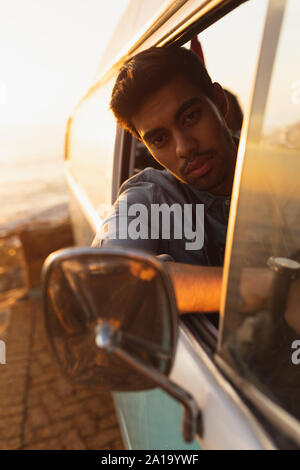 young mixed race man sitting in the front seat of a van Stock Photo