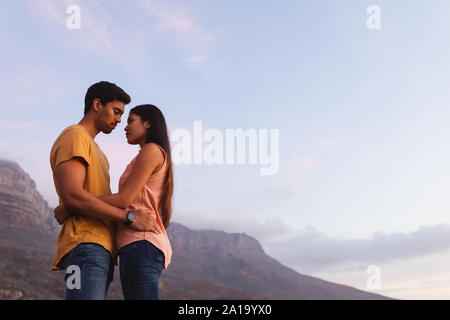 young mixed race couple standing on a beach Stock Photo