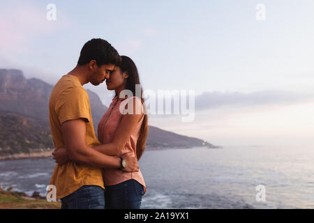 young mixed race couple standing on a beach Stock Photo