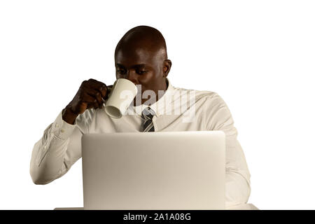 Businessman using a laptop and drinking coffee Stock Photo