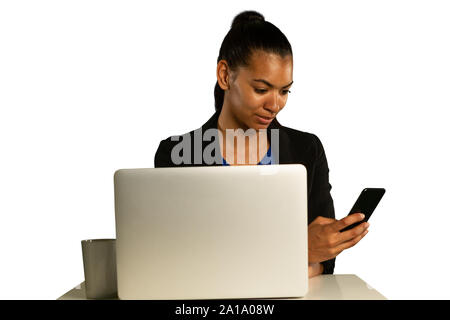 Young businesswoman using a laptop and smartphone Stock Photo