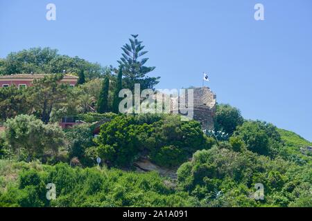 Ruin of a Genoese tower on a greened cliff Stock Photo