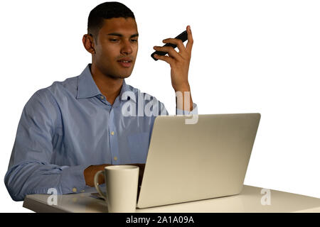 Young businessman using a laptop and a smartphone Stock Photo