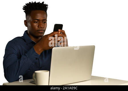 Young businessman using a laptop and a smartphone Stock Photo