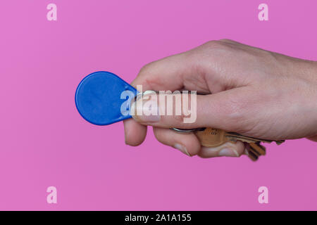 hand holding an automatic door entry tag on a key ring Stock Photo