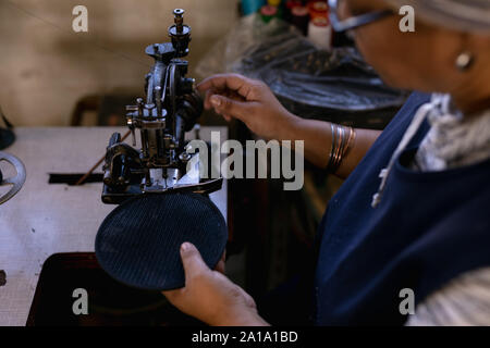 Woman using sewing machine in a hat factory Stock Photo