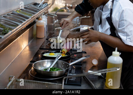 Chefs working in busy restaurant kitchen Stock Photo