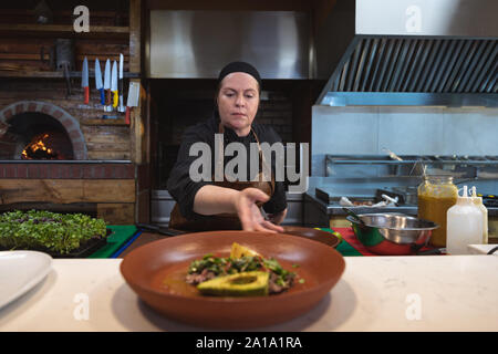 Woman working in restaurant kitchen Stock Photo