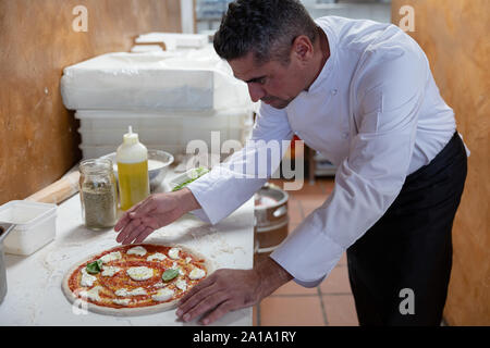 Head chef preparing pizza in a restaurant Stock Photo