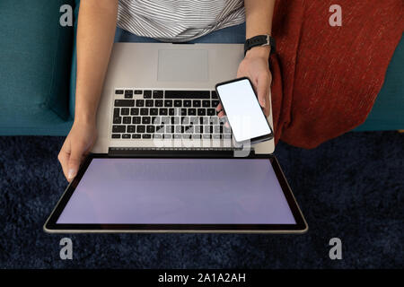 Woman using a smartphone and laptop Stock Photo