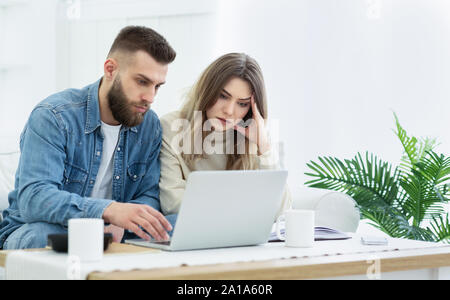 Young couple using laptop for managing expanses Stock Photo