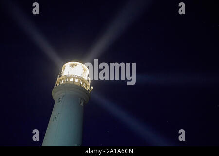 Flamborough Head lighthouse at night showing four warning light beams, East Yorkshire, UK Stock Photo