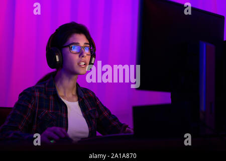 Professional gamer girl playing and streaming online video game Stock Photo