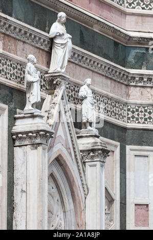 East entrance to Giotto's Campanile tower, Florence, Italy. 'Two Prophets and the Redeemer' on top of the gable above the entrance door, are both attr Stock Photo