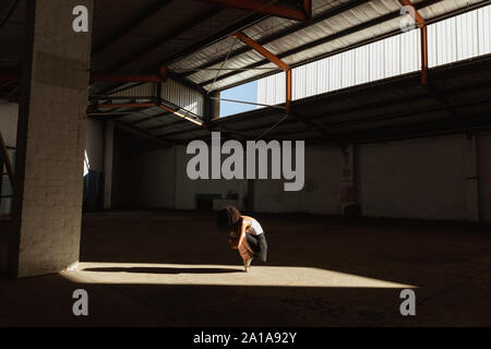 Female dancer in an empty warehouse Stock Photo