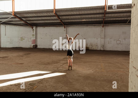 Female dancer in an empty warehouse Stock Photo