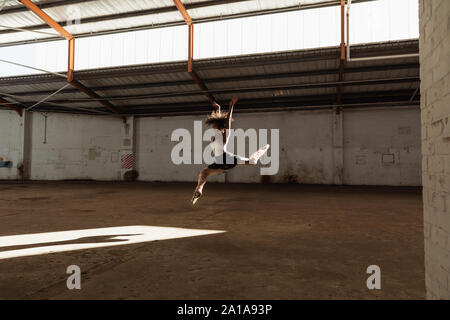 Female dancer in an empty warehouse Stock Photo