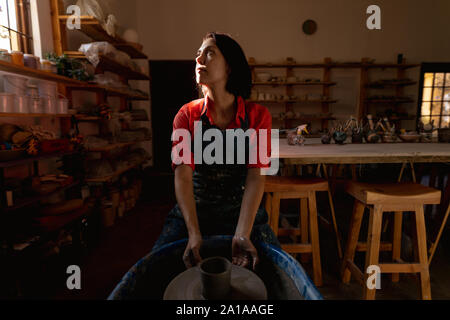 Female potter in a pottery studio using pottery wheel Stock Photo