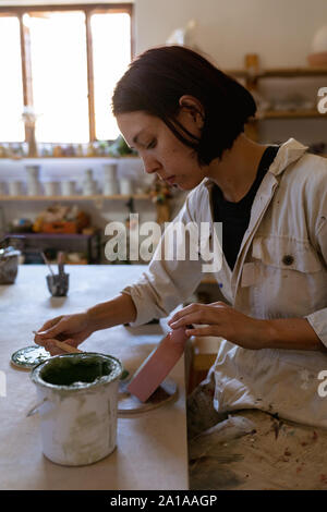 Female potter at work in a pottery studio Stock Photo