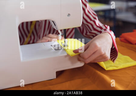 Young female student using sewing machine at a fashion college Stock Photo