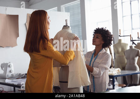 Female students working on a garment at a fashion college Stock Photo