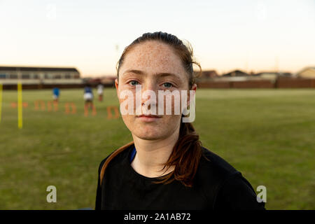 Portrait of young adult female rugby player on a rugby pitch Stock Photo