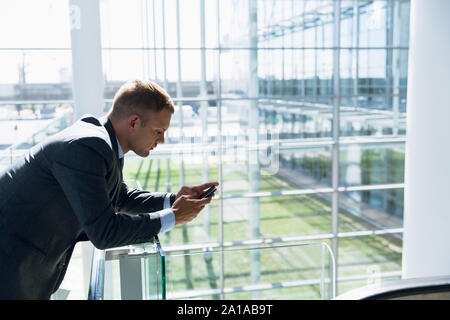 Businessman using mobile phone in the corridor Stock Photo