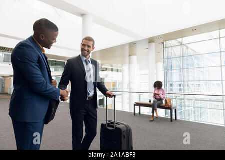 Travelling businessmen shaking hands Stock Photo